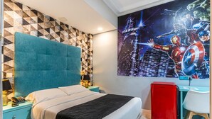 A bedroom with a bed, a nightstand, a desk, and a wall with a superhero-themed mural. - Hotel Mexico (Madrid)