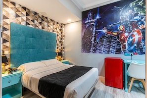 Una camera da letto con un letto, un comodino, una scrivania e una parete con un murales a tema supereroi.