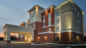 A modern hotel with a prominent sign, a covered entrance, and a parking area. - Homewood Suites by Hilton Kalamazoo-Portage (Portage)