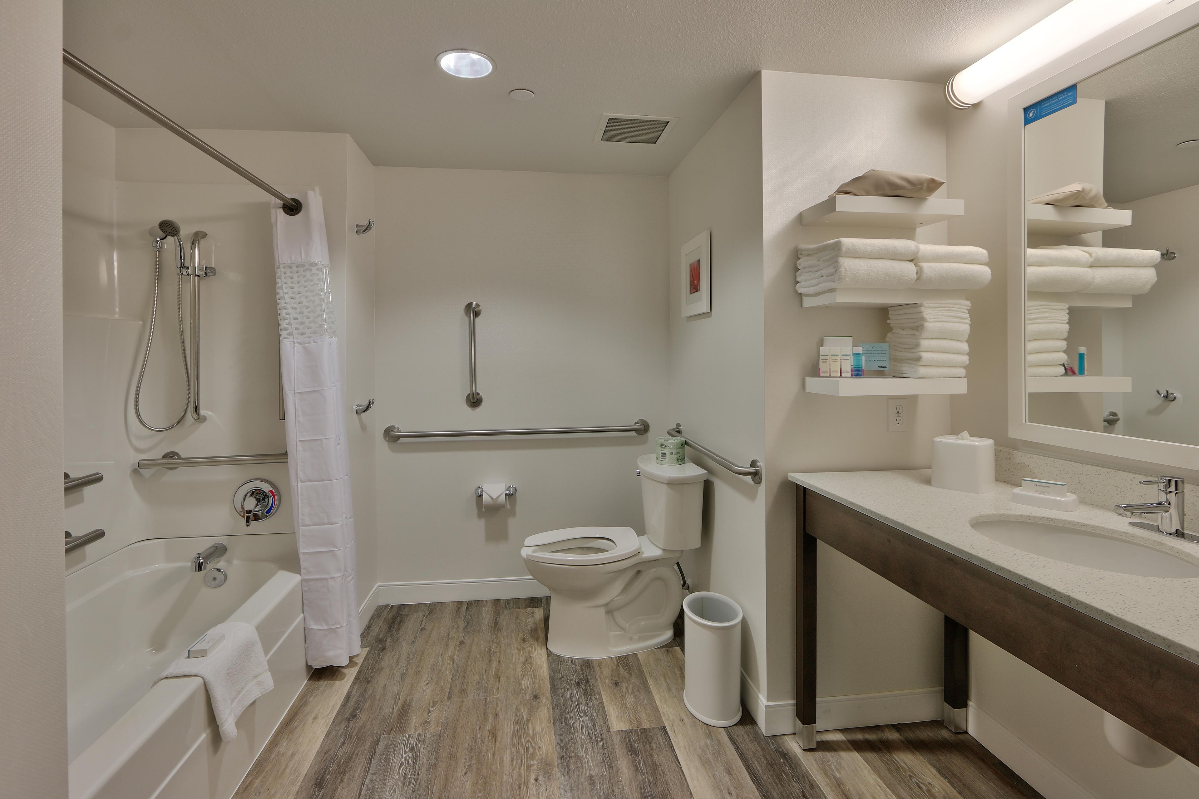 A modern bathroom with a bathtub, toilet, and sink.