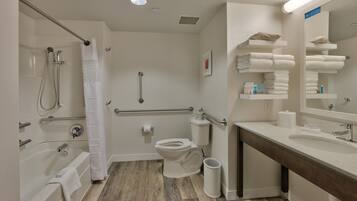 A modern bathroom with a bathtub, toilet, and sink.