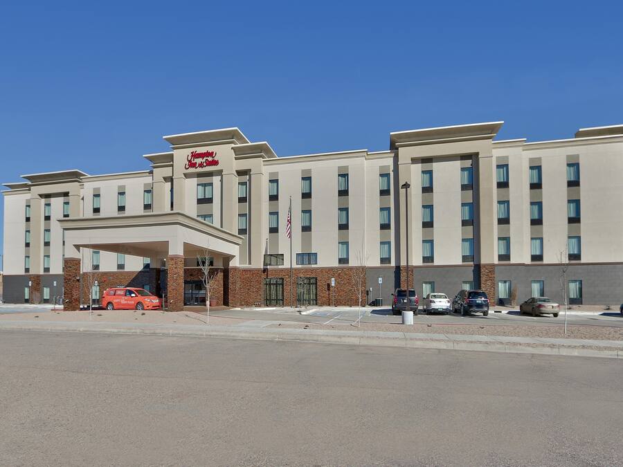 A hotel with a modern design, featuring a prominent entrance and multiple floors.