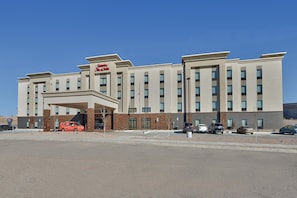Ein Hotel mit modernem Design, das einen markanten Eingang und mehrere Stockwerke aufweist.
