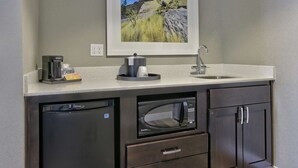 A compact kitchen with a dishwasher, a built-in microwave, a coffee maker, and a sink. - Hampton Inn & Suites Albuquerque Airport (Albuquerque)
