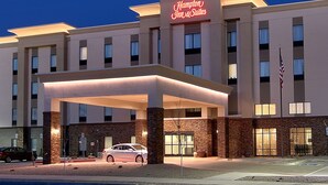 A Hampton Inn & Suites hotel with a covered entrance, multiple floors, and an American flag. - Hampton Inn & Suites Albuquerque Airport (Albuquerque)