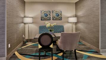 A conference room with two chairs, a table, and two wall-mounted lamps.