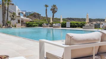 Una piscina cubierta, una piscina al aire libre de temporada, sombrillas