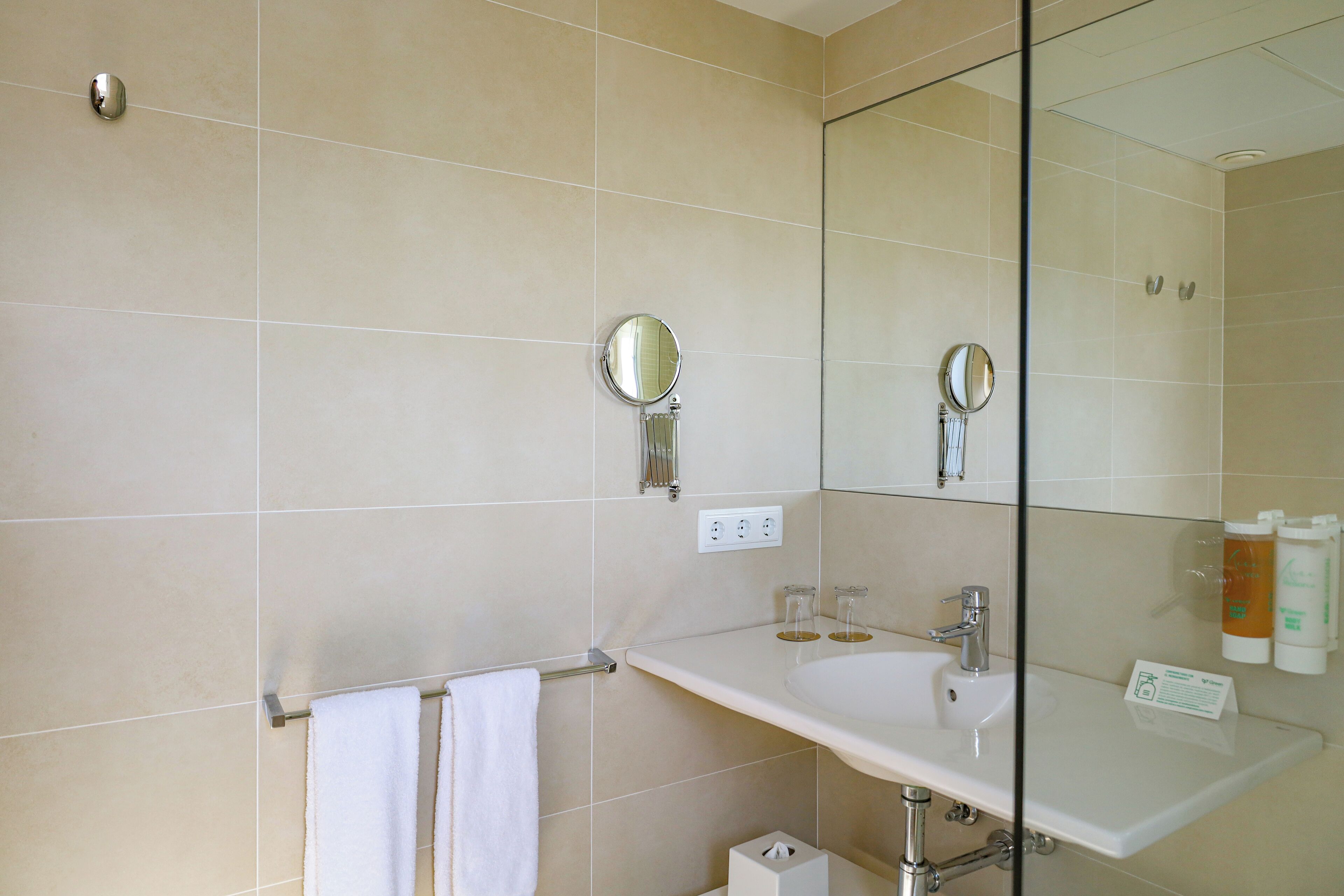 Une salle de bain avec un lavabo blanc, un miroir et un porte-serviettes.