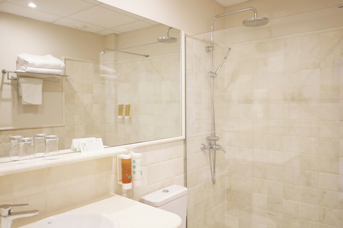 A modern bathroom with a glass-enclosed shower, a sink, and a toilet.