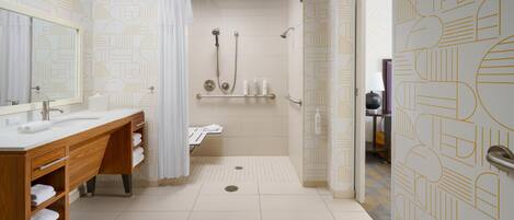 A modern bathroom with a shower, a vanity with a mirror, and a toilet.