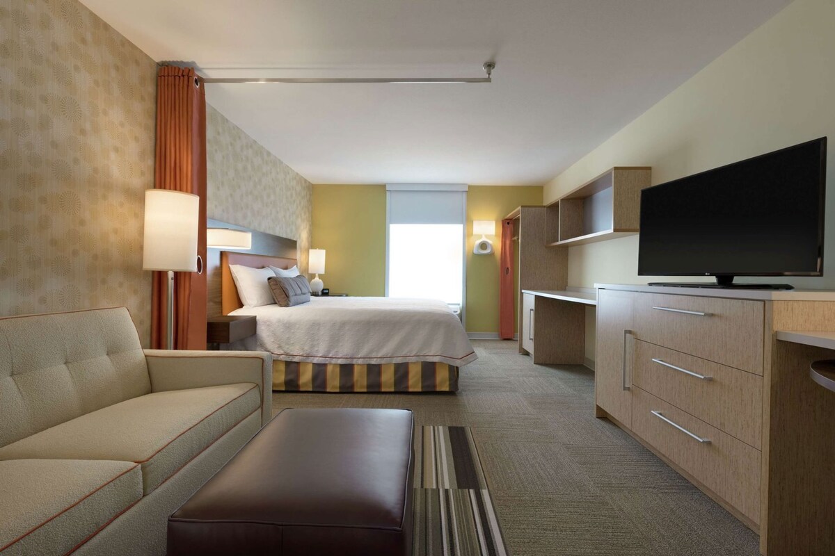 Une chambre d’hôtel comprenant un lit, un canapé, une télévision, un bureau et une salle de bain.