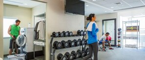 A gym with a rack of dumbbells, a television, and a sign for 'SPIN2CYCLE'. - Home2 Suites by Hilton Atlanta South/McDonough (McDonough)