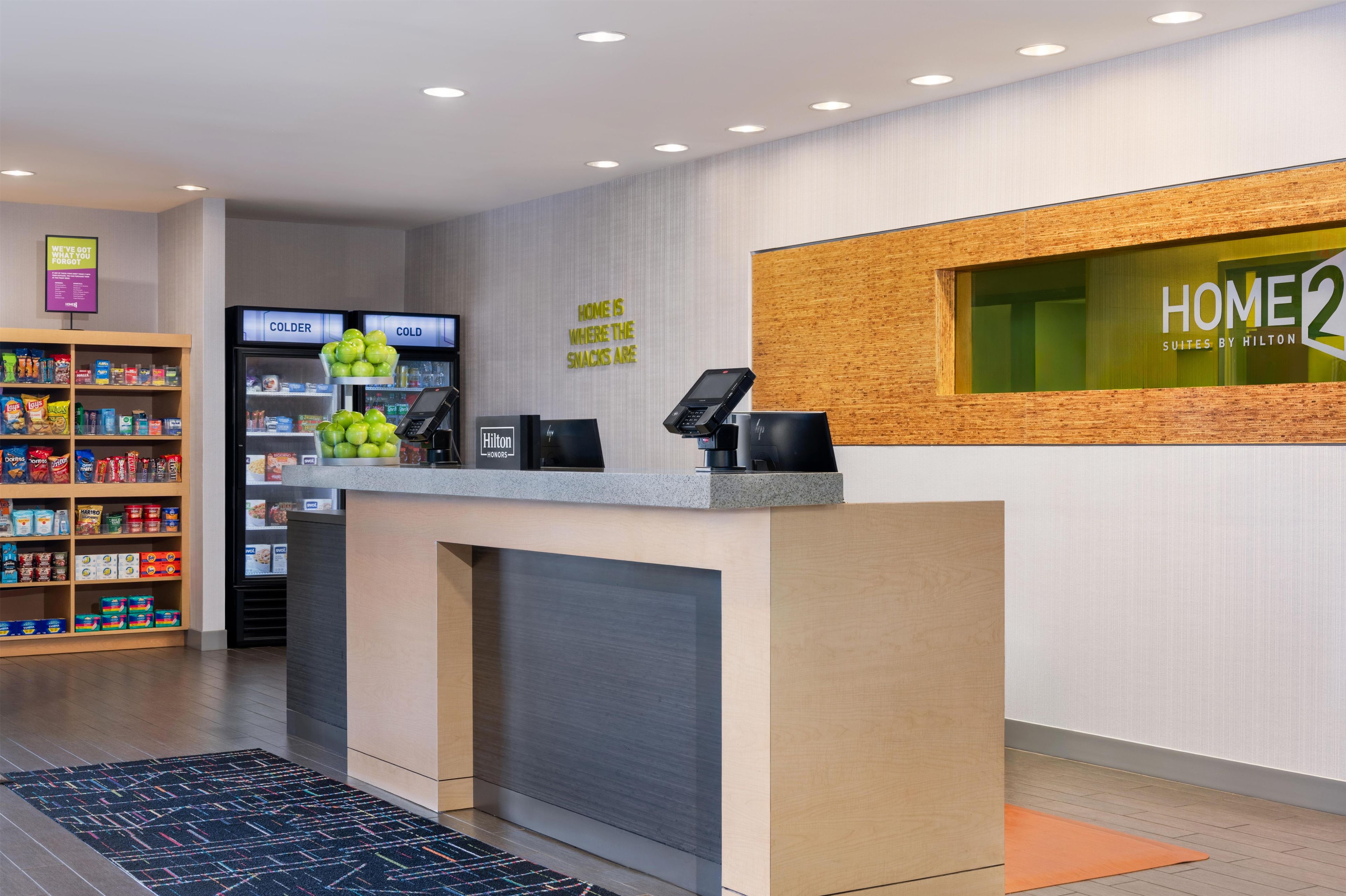 A hotel reception area with a counter, vending machines, and a display of snacks.