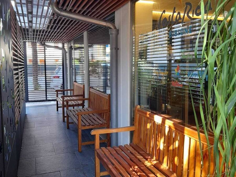 Un espacio al aire libre con bancos de madera y un escaparate de vidrio.