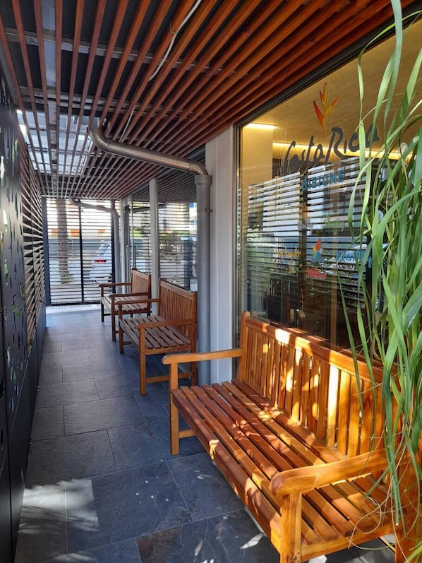 Un espacio al aire libre con bancos de madera y un escaparate de vidrio.