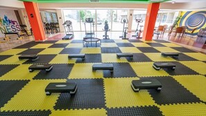 A gym with exercise equipment and a checkered floor.