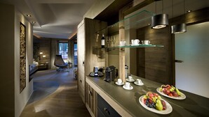 Een moderne keuken met een houten aanrecht, glazen planken en een eethoek met een tafel gedekt voor twee personen.