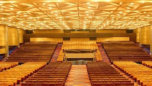 A large auditorium with tiered seating and a geometric ceiling design.