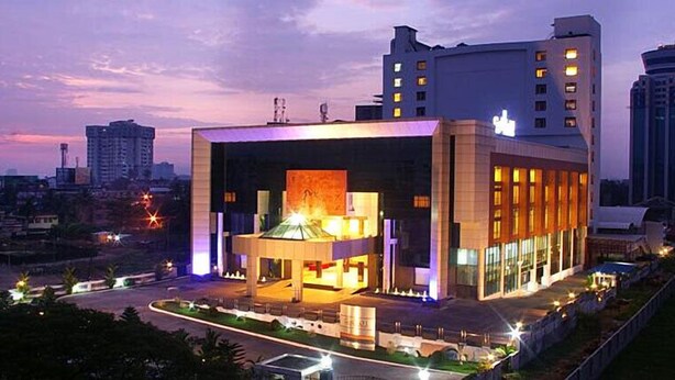 A modern hotel with a central atrium, surrounded by high-rise buildings.