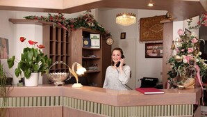 A reception desk with a telephone, a red notebook, and a decorative lamp. - Astoria Hotel Trier (Trier)