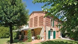 A brick house with a stone foundation, a covered porch, and a well-maintained garden. - Villa Fontine (Castelfranco di Sotto)