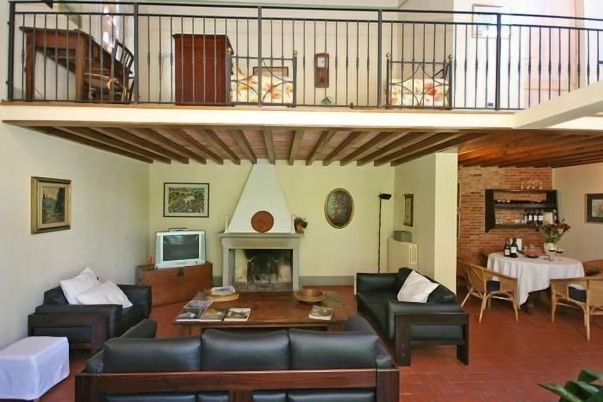 A spacious living room with a fireplace, a balcony, and a dining area.