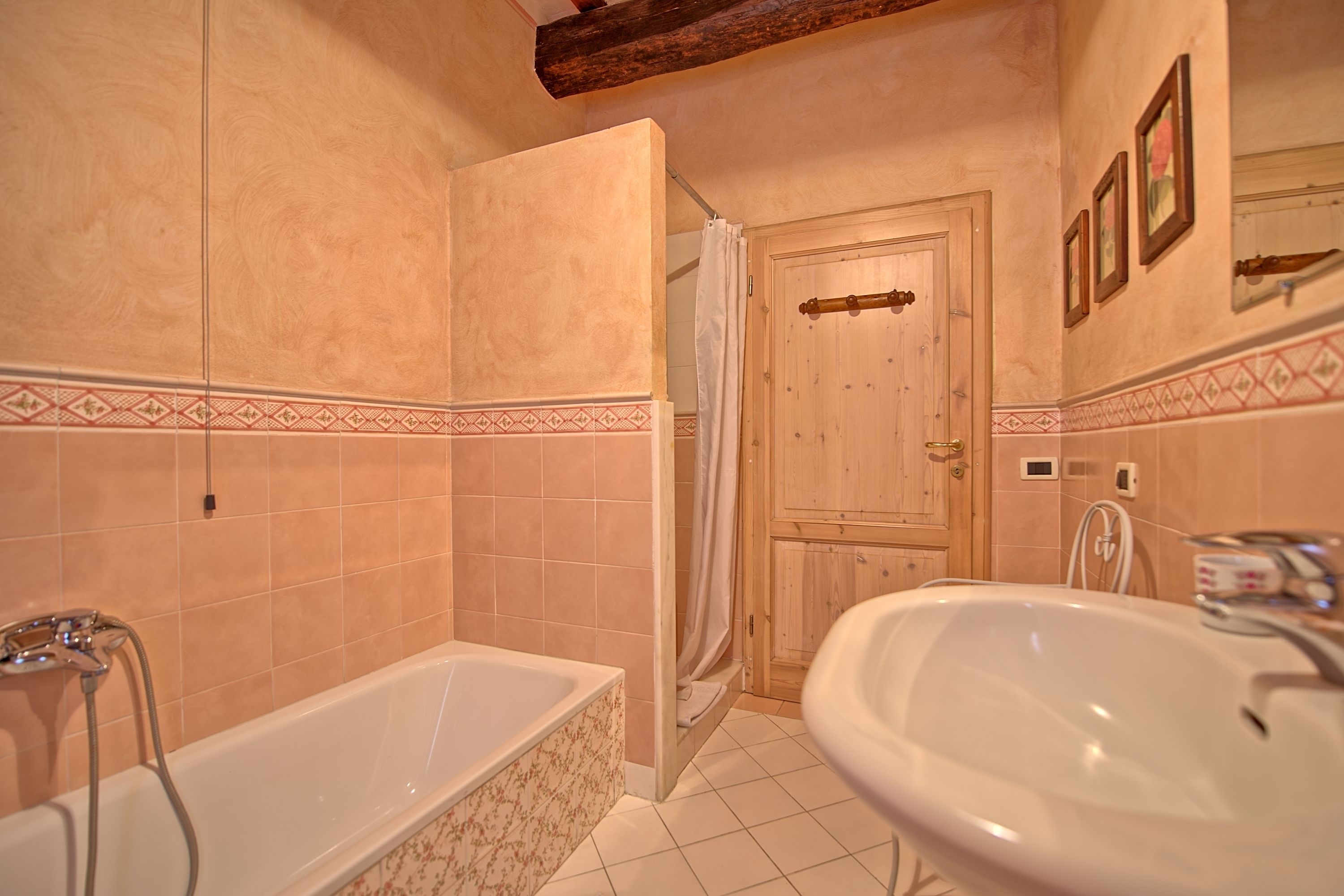 A bathroom with a bathtub, a sink, and a shower area.
