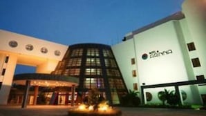 A modern hotel with a curved glass facade, a central atrium, and a well-lit entrance. - Arinna Hotel (Manavgat)