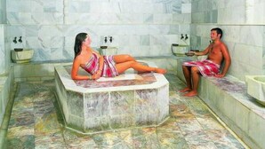 A spa room with a marble bathtub, a separate seating area, and a sink. - Arinna Hotel (Manavgat)