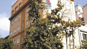 A multi-story hotel with a prominent 'K' logo on the facade, featuring balconies and a classic architectural style. - Alcor Hotel (Mendoza)