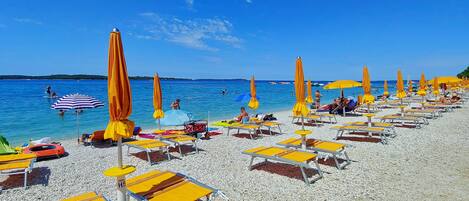On the beach, white sand, beach umbrellas, beach volleyball