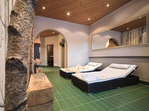 A room with two beds, a wooden ceiling, and a green floor. - Montjola (Sankt Anton am Arlberg)