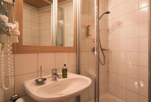 A bathroom with a sink, mirror, and shower. - Montjola (Sankt Anton am Arlberg)