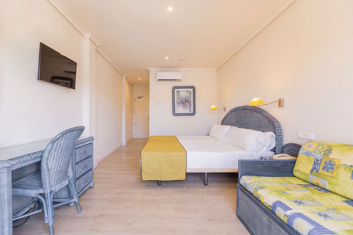 Une chambre d’hôtel avec un lit, un canapé, un bureau et une chaise.