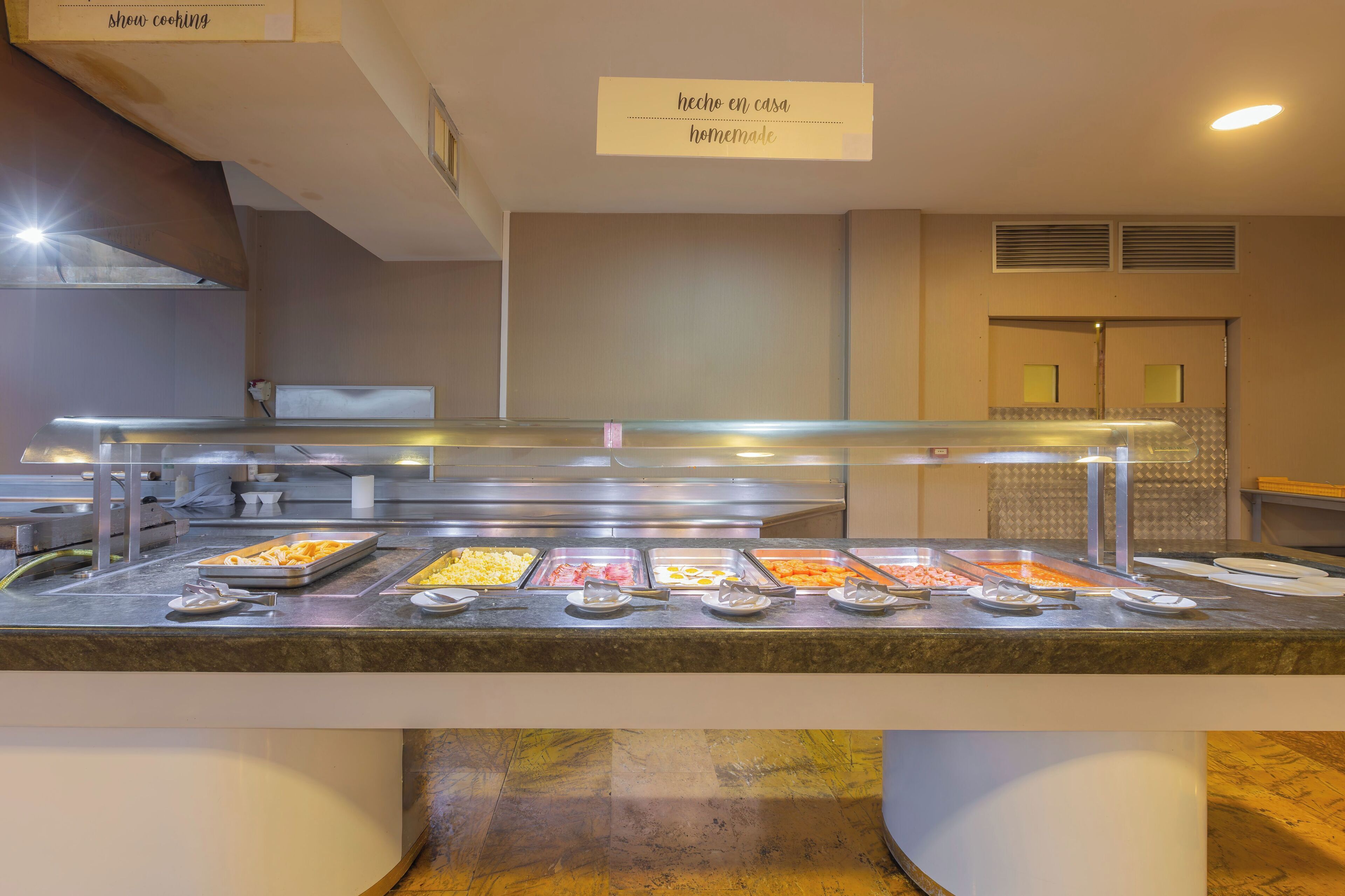 Een buffet met diverse gerechtjes, een bordje met huisgemaakte gerechten en een schoon, modern keukenhoekje.