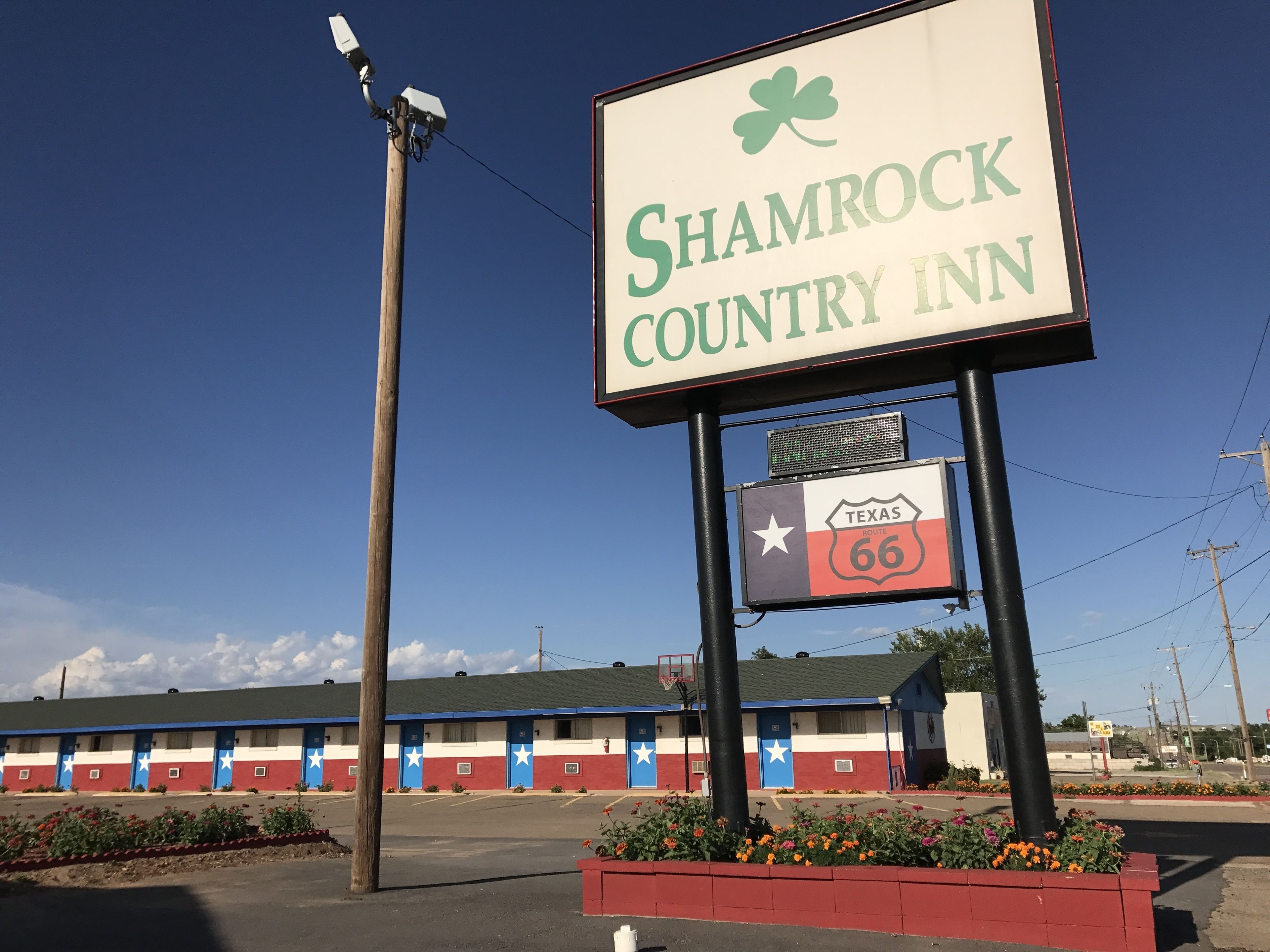 A Shamrock Country Inn sign with a Texas Route 66 marker below it.