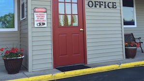 A building with a red door, a sign indicating video surveillance, and the word "OFFICE" on the wall. - Relax Inn (Saginaw)