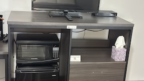 A compact kitchenette with a microwave, toaster, and a small refrigerator. - Relax Inn (Saginaw)