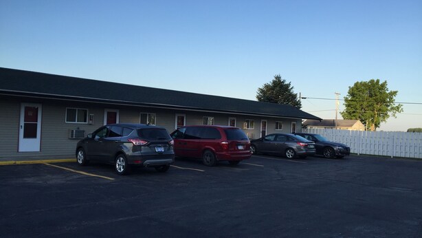 A motel with three parked cars in front. - Relax Inn (Saginaw)