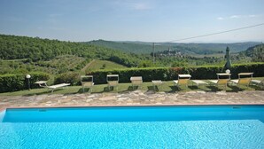 A swimming pool with lounge chairs and a view of a green landscape. - Casa Anna (Barberino Tavarnelle)