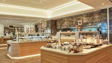 Un espace buffet agrémenté d’un mur en marbre, d’un comptoir en bois et de divers plats.