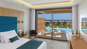 Une chambre d’hôtel avec un lit, une chaise, une table où le petit-déjeuner est servi, et une vue sur une piscine et des bâtiments.
