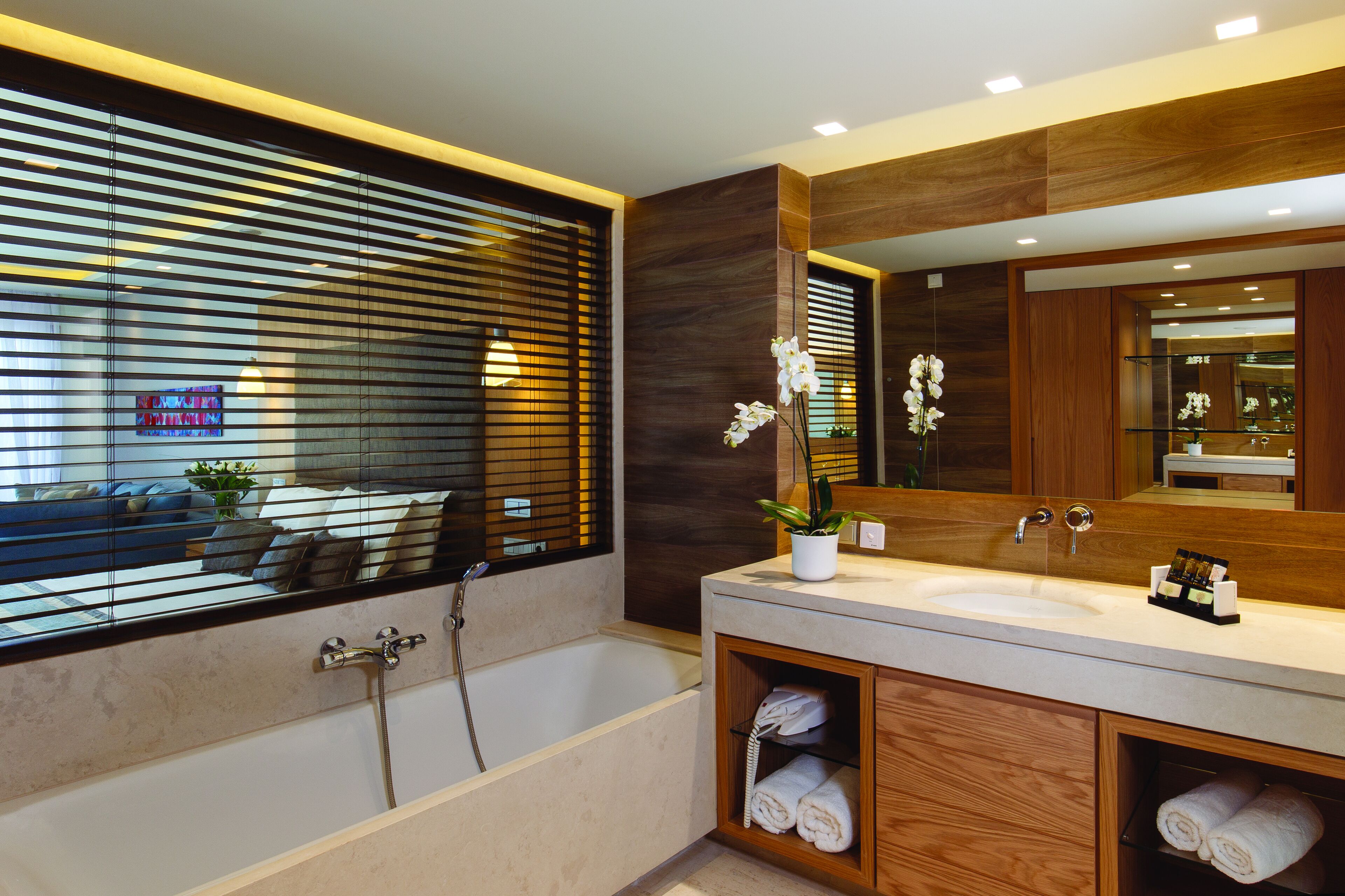 Un baño moderno con bañera, un espejo grande y un tocador con lavabo.