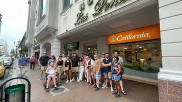 A group of people standing in front of a hotel named "HOTEL Las Palmas."