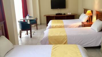 Habitación de hotel con dos camas, televisor, escritorio y silla.