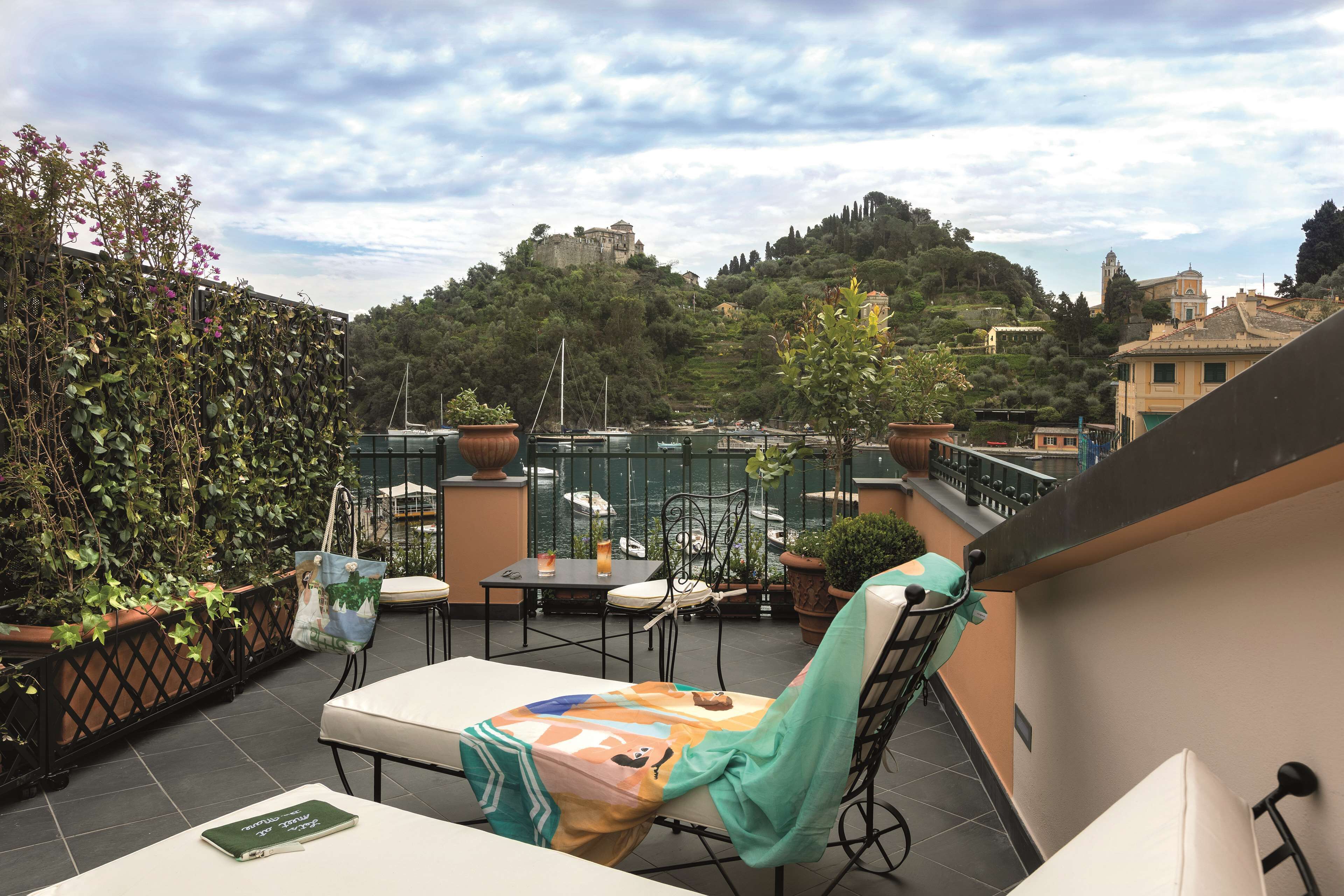 Eine Terrasse mit Tisch, Stühlen und Blumentöpfen.
