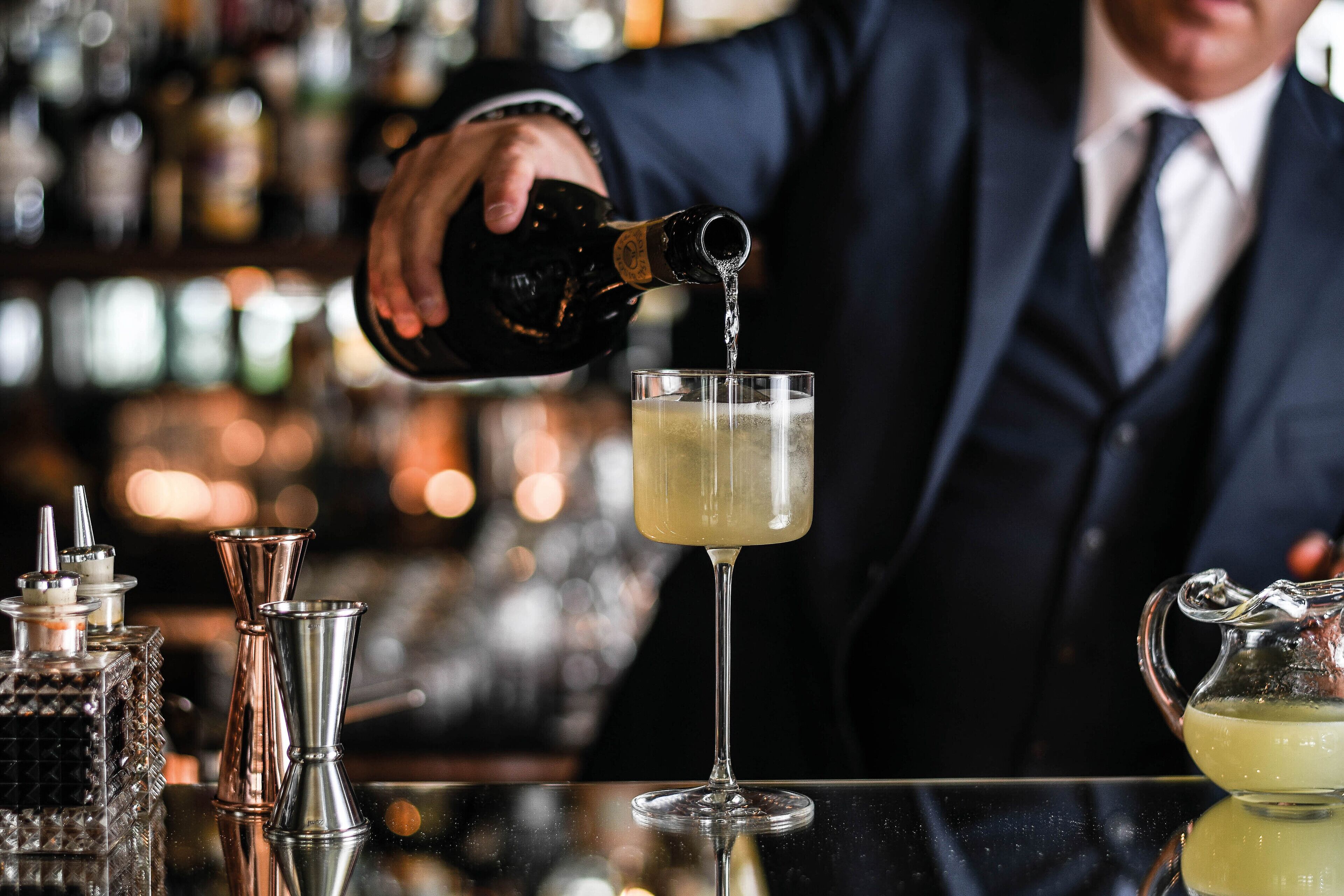 Un bar, avec un barman en train de verser une boisson dans un verre.
