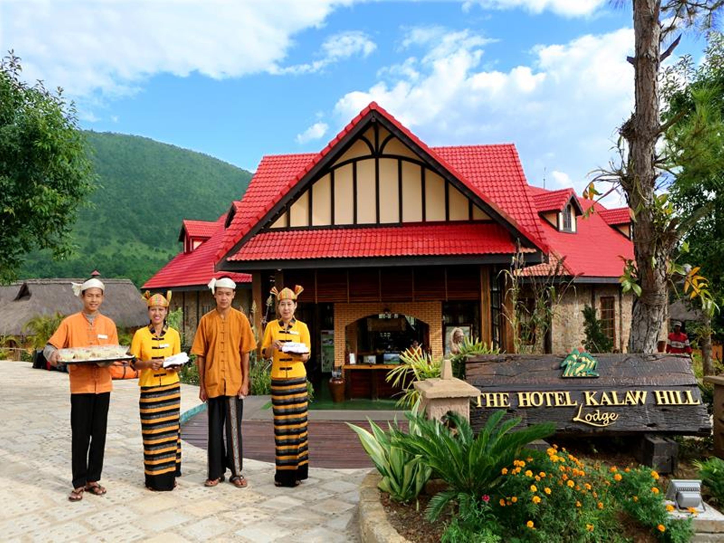 Ett hotell med ett rött tak och en skylt som visar texten ”The Hotel Kalaw Hill Lodge”.