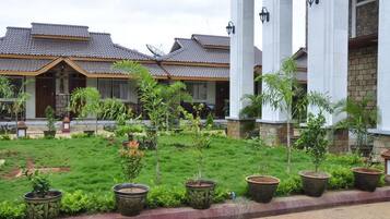 Un hotel con varias construcciones, cada una con tejado de baldosas y un jardín con plantas en macetas.