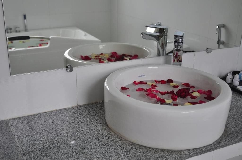 Un baño con un lavabo redondo, un espejo y una bañera.
